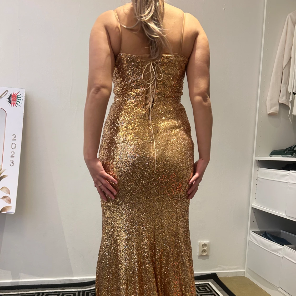 Glittrig guldig långklänning med snörning i ryggen