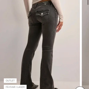 Grå bootcut jeans från True Religion - Snygga grå jeans från True Religion med bootcut passform och låg midja. Jeansen är i jättefint skick är super snygga. Men kommer tyvärr inte till användning, dom är köpta på Nelly. Skriv om ni vill ha bilder på byxorna