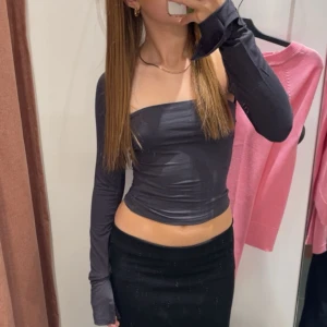 Mörkgrå offshoulder långärmad topp - Säljer en mörkgrå, tight och croppad offshoulder topp med långa ärmar från ginatricot.