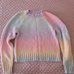 Pastellfärgad stickad tröja Lindex - Superfin oanvänd stickad tröja från Lindex i mjuka pastellfärger som lila, rosa, gul och mintgrön. Tröjan har rund halsringning, ribbade muddar och långa ärmar. Perfekt för dig som gillar färg och vill ha en mysig look.