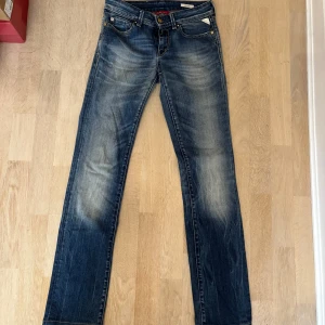 Blå Replay Pearl jeans med raka ben - Säljer ett par blå Replay Pearl jeans med snyggt slitna detaljer och kontrastsömmar. Jeansen har raka ben, klassiska fem fickor och coola broderier på bakfickorna. Materialet är mjukt jeans i bomull och passformen är normal. Perfekta för dig som gillar en avslappnad men stilren look. Storlek 27/34!🩷