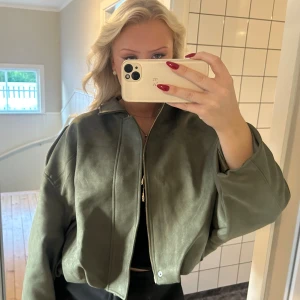 Viral mocka jacka grön - Den virala bomberjacka i mockaimitation med lite oversized passform. Jackan har klassisk krage, dragkedja framtill och långa ärmar. Exakt som den supertrendiga jackan från Zara! Passa på innan den säljer❤️❤️💖💖Kom gärna med prisförslag! det är en M men passar en S då jag är de, ALDRIG ANVÄND DESSUTOM🤩