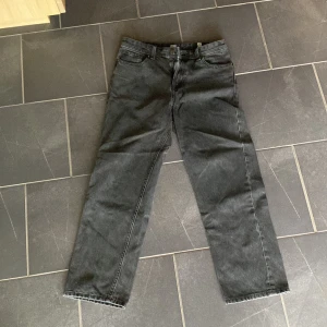 Svarta jeans från Jack & Jones  - Svarta jeans från Jack & Jones i rak modell. Klassisk femficksdesign med bälteshällor och knappgylf samt dragkedja.Jeansen har en enkel och stilren look som passar till det mesta. Tillverkade i slitstarkt jeanstyg för en tidlös vibe.pris kan diskuteras 