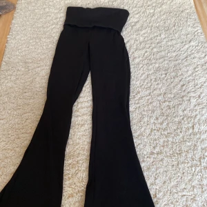 Svarta bootcut byxor från Lindex - Svarta ribbade byxor från Lindex i storlek 152. Byxorna har hög midja och utsvängda ben i bootcut-stil. Mjukt och stretchigt material som sitter skönt och följer kroppen. Perfekta för en trendig och avslappnad look.