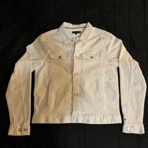 Vit jeansjacka Tommy Hilfiger  - Vit jeansjacka från Tommy Hilfiger. Jackan har broderad logga på ryggen. Jackan är i väldigt bra skick då den är använd en gång! Pris kan diskuteras☺️