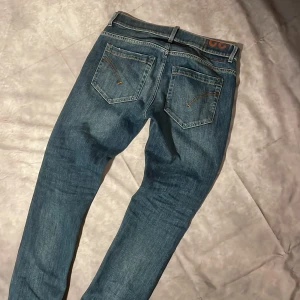 Dondup George - Snygga blå  jeans från Dondup med klassisk femficksdesign och slitna detaljer på benen. Jeansen har en smal passform och är tillverkade i mjukt denimtyg som ger en skön känsla. Storlek 32 och skick 8/10. Ny pris runt 3000, mitt pris 649. Modell George sitter slim och passar perfekt om man är runt 165-175
