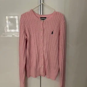 Rosa kofta från Polo Ralph Lauren - Säljer en jätte söt rosa kofta från polo Ralph lauren med mörkblå märke/häst. Koftan är i storlek 12-14 år eller L i barnstorlek. Den e använd få gånger och i mycket bra skick.