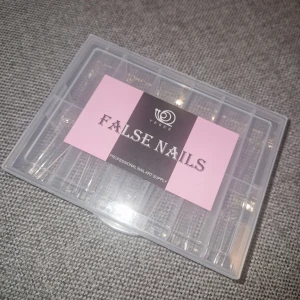 Lösnaglar - Säljer ett set med genomskinliga lösnaglar. Naglarna kommer i en praktisk plastask med flera fack för olika storlekar. Perfekt för att skapa egna nageldesigner eller förlänga dina naturliga naglar. 