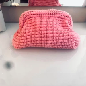 Rosa stickad cluch bag  - Superfin rosa cluch bag köpte två i Grekland en till min vän som tyvärr hade en liknande. Aldrig använd. Hör av er för frågor❤️