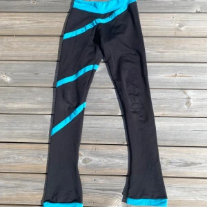 Konståkning sleggings med turkosa detaljer - Leggings med turkosa ränder. Snygg sportig look, perfekta för träning eller chill. Stretchigt material som sitter bekvämt! Defekt visas på bild 3! 😇