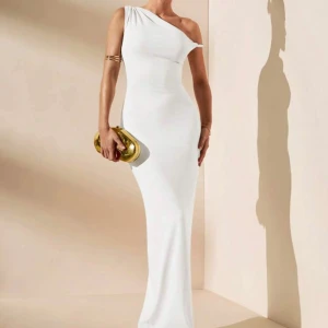 One shoulder långklänning  - Säljer en Vit  one shoulder klänning som är oanvänd och har prislappen på