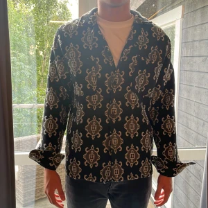 Svart mönstrad overahirt Les Deux L - Säljer en svart ocershirt från Les Deux med unikt beige mönster över hela plagget. Ednast använd 1 gång, nypris 1500 