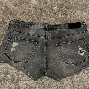 Grå slitna jeansshorts med leoparddetalj - Snygga grå jeansshorts med slitna detaljer och råa kanter. Leopardmönstrat tyg syns under de trasiga partierna framtill.💕