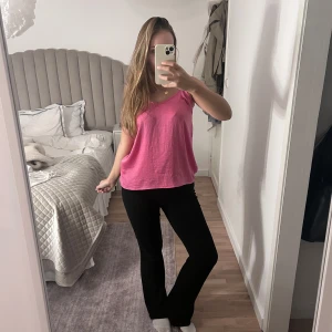 Rosa linnetopp med v-ringning - Säljer en enkel och snygg rosa linnetopp med v-ringad hals. Toppen är ärmlös och har en avslappnad passform, perfekt för varma dagar. Materialet känns lätt och luftigt, vilket gör den superbekväm att bära.