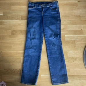 Dr Denim Dixy Straight jeans blå M/30 - Snygga blå jeans från Dr Denim i modellen Dixy Straight. Klassisk femficksdesign, raka ben och normal passform. Jeansen är tillverkade av återvunnen bomull och har en mörkblå tvätt med kontrastsömmar. Perfekta för en clean och stilren look.