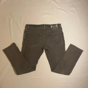 Jacob Cohen Jeans - Ett par riktigt schyssta jeans från det italienska märket Jacob Cohen. Jeansen har använts väl men är i gott skick som visar på dess goda kvalitet. Med snygga detaljer och en clean grå tvätt är dom ett nyckelplagg i garderoben, både för vardagen men även för kavaj och skjorta. Storleken är size 34 och vid intresse eller frågor är det bara att höra av sig :)