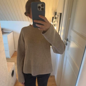 Beige stickad tröja från & Other Stories - Säljer en beige stickad tröja från & Other Stories Paris Atelier i storlek XS. Tröjan har rund hals, långa ärmar och breda ribbade muddar vid ärmslut och nederkant. 