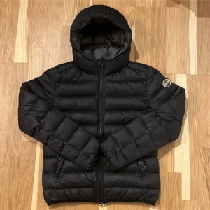 Svart pufferjacka från Colmar - Säljer en svart pufferjacka från Colmar med huva och dragkedja framtill. Perfekt för kalla dagar nu på hösten  och har en stilren look med Colmar-logga på ärmen. Säljer en stilren svart dunjacka från Colmar. strl 42 (164-172). . På insidan av höger arm finns några få defekter (se sista bilden) men det är inget som syns vid användning. Tveka ej på att fråga om du undrar något🤝 pris kan diskuteras.