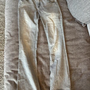 Ljusgrå bootcut jeans från Mavi - Jeansen är använda men fortfarande i fint skick, förutom slitningen längs ner (se bild 4). Byxorna är i storlek 28/32 (28 i waist, 32 i längd). Själv är jag 169 cm och de är lite långa på mig. Jag ansåg att dessa byxor va lite stora för mig och har därför sytt in ett skosnöre på insidan som tillkommer, men de är hur enkelt som helst att ta bort utan att det syns på utsidan att det har varit där (när man har på sig de med skosnöret syns det inte heller). 💕💕frakt ingår ej