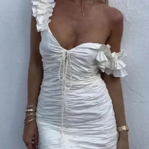 ZARA strl S vit klänning med volanger - Fin vit sommarklänning från Zara med volanger. Strl small. Har ett hål på insidan av klänningen, men ingenting som syns. Två första bilderna är lånade 