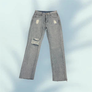 Blå slitna raka jeans  - Blå jeans med raka ben och slitna detaljer på låret och knäet. 