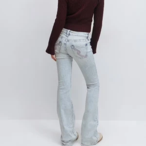 Ljusblå bootcut jeans med rosa detaljer - Säljer ett par populära ljusblå bootcut jeans med snyggt broderi på bakfickorna. Jeansen är endast använda 2 gånger. Dom är assnygga men tyvärr lite stora för mig och jag har för mycket jeans! Dom är i storleken M men skulle säga att dom är S/M. Mått går att hitta på ginas hemsida!