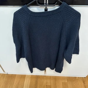 Mörkblå stickad tröja  - Snygg mörkblå stickad tröja  i storlek XS. Tröjan har en rund halsringning och trekvartsärmar. Materialet är grovstickat och ger en skön känsla. 