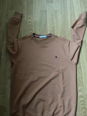 Brun sweatshirt från Tommy Hilfiger - Det står L men den sitter som M