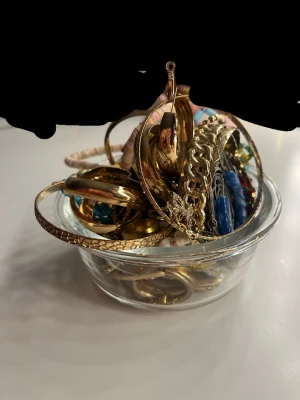 Massa bra olika smycken - Bilden visar en skål fylld med smycken, armband, örhängen, halsband, ringar  i guld, silver  och färgade detaljer. Detta är jätte många smycken. Jag är öppen för andra priser💕💕