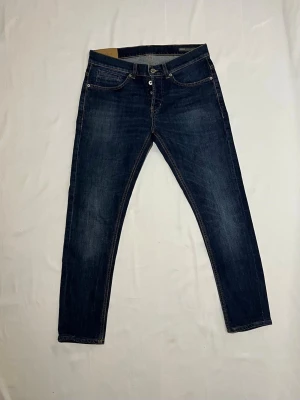 DONDUP JEANS - George - Hej! Säljer ett par riktigt snygga Dondup jeans i en ljusblå färg. Storlek 31. Modellen är George, en väldigt populär passform som sitter riktigt bra och är väldigt stilrent. Jeansen är i bra skick.  Hör gärna av er om ni har frågor! 