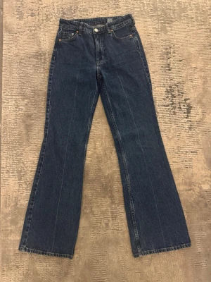 Bootcut jeans blå - Säljer ett par bootcut jeans i färgen mörkblå denim, high waist från H&M i storleken 34!