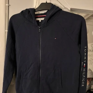 Tommy Hilfiger Zip Hoodie - Hej🥰 säljer nu min Zip Hoodie från Tommy Hilfiger. Den är mörkblå i storlek 164 (motsvarar ungefär xs). Använd fåtal gånger, hör av er vid frågor eller funderingar💕