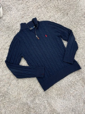 Polo Ralph Lauren stickad 1/4 zip - Otroligt snygg stickad tröja ifrån Ralph Lauren med en 1/4 zip dragkedja🙌storlek M, tröja är i ett väldigt fin skick där den ända skavanken är en liten missfärgning vid ärmen vilket knappt syns😇(se sista bilden) vid frågor/ prisförlag tveka inte med att höra av dig🫡