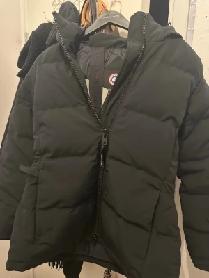 Chelsea parka canada goose  - Svart pufferjacka från Canada Goose med huva och tydlig logotyp på ärmen. Storlek S. Har haft den en två vinter. Inga sliter och skador på jackan. Köpt för 15 975kr. Köpt utan päls men köpte pälsen separat. Så ifall du är intresserad av pälsen skriv. Pris går att diskutera. 😊