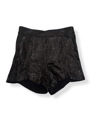 Svarta paljettshorts från Zara - Svarta shorts från Zara, täckta med glittriga paljetter som ger en riktigt snygg och festlig vibe. Modellen är högmidjad. Perfekta för att sticka ut och glänsa när du vill vara extra.