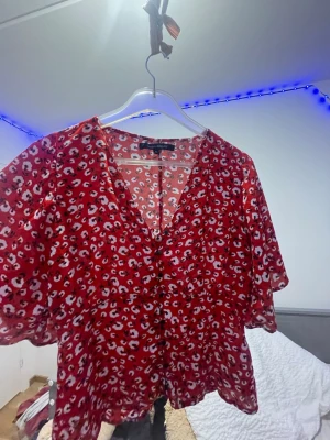 Röd tröja med djup vcut  - Röd tröja med blommor och djup vcut 