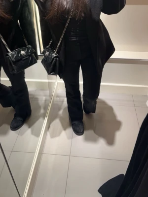 Svart quiltad handväska från Kurt Geiger - Säljer en svart quiltad handväska från Kurt Geiger med silverfärgad kedja och snyggt fågelhuvud som detalj på locket. Väskan är tillverkad i skinn och har en kompakt, rektangulär form. Perfekt för dig som gillar stilrena accessoarer med en cool twist. Kan tänka mig att gå ner i pris vid snabb affär💕