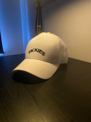 Bågad Dickies Keps - Bilderna visar en vit keps från Dickies med mesh på baksidan och justerbar rem