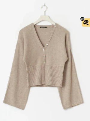 Beige kofta från Gina Tricot - Superfin beige kofta med v-ringning och knappar framtill från Gina Tricot. Modellen är croppad med bred ribbad midja och vida ärmar.  Är ej använd och har kvar prislappen 