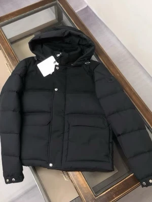 Svart pufferjacka från Moncler - Svart pufferjacka från Moncler med huva och stora fickor framtill. Jackan har både dragkedja och knappar, samt ribbad insida vid halsen. Perfekt för kalla dagar och har en clean, modern look som funkar till streetwear. Pris kan diskuteras vid snabbaffär!