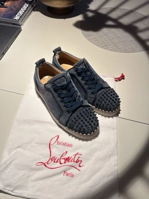 Christian Louboutinblå - Ett par sällsynta Christian Louboutin i riktigt bra skick. Mockan är inprincip perfekt och det är endast lite smuts på undersidan på vänster sko som säkert enkelt går att tvätta bort. Nypris cirka 11000kr strlk 39,5 men sitter som 40-41 det är endast en liten skavank på hela skon som sitter i hälen