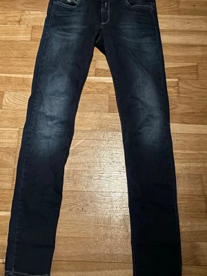 Replay Hyperflex mörkblå jeans - Säljer ett par mörkblå Replay Hyperflex jeans med snygg tvätt och klassisk femficksdesign. Jeansen har smal passform och stretchigt material som gör dem riktigt bekväma. Perfekta till sneakers eller boots och funkar året runt.