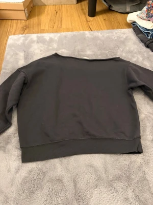 Svart sweatshirt från H&M - En basic svart sweatshirt från H&M i storlek 158/164. Tröjan har rund hals, långa ärmar och breda muddar vid ärmslut och nederkant. Tillverkad i mjuk bomullsmix som är skön att ha på sig. Perfekt till chill dagar eller när du vill ha en enkel look.