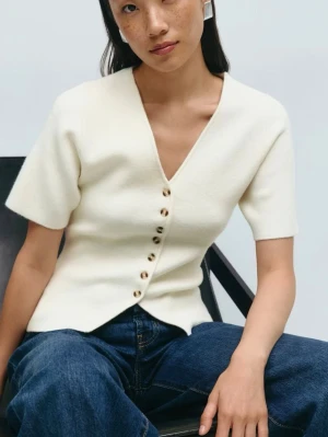 Vit topp med v-ringning och knappar - Säljer en stilren vit kofta med v-ringning och snygga knappar framtill. Endast använd en gång