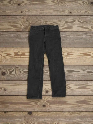 Svarta raka jeans - Säljer ett par raka jeans med klassisk femficksdesign och raka ben. Jeansen har normal passform och är tillverkade i ett slitstarkt jeanstyg. Perfekta till en avslappnad stil och funkar året runt. Jag är inte säker på storleken med det står på bilden.