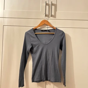 Blå långärmad tröja - Säljer en stilren blå långärmad tröja med v-ringning. Perfekt för både vardag och lite finare tillfällen. Tröjan är i bra skick och passar perfekt till höst- och vårgarderoben. Skön och enkel att matcha med olika outfits! Lätt och tunn material. Använt fåtal gånger.