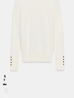 Vit stickad tröja med knappar från Zara  - Snygg vit stickad tröja med rund hals och långa ärmar. Tröjan har coola svarta knappar som detalj vid ärmsluten och en slim passform som sitter snyggt på kroppen. Perfekt att matcha med jeans eller kjol för en clean look.