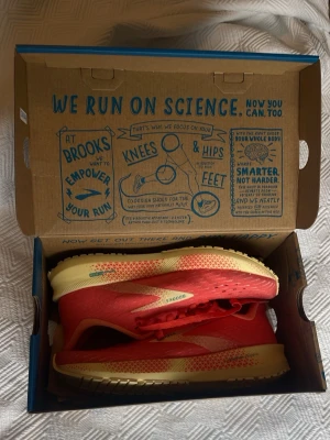 Brooks Hyperion Tempo löparskor dam 38 - Säljer ett par oanvända Brooks Hyperion Tempo (NYSKICK) löparskor i storlek 38. Säljer pga fel storlek. Skorna är korallröda med ljusgula detaljer och har en lätt och ventilerande ovandel i syntet. Sulan är designad för bra grepp och respons. Perfekta för dig som gillar att springa snabbt och smidigt.