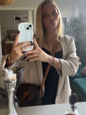 Louis Vuitton brun axelväska i skinn - Säljer min äkta Louis Vuitton axelväska med klassiskt monogrammönster och justerbar ljusbrun axelrem. Äktahetsbevis skickas med!Väskan har lock med spänne och är tillverkad i skinn. Perfekt storlek för det viktigaste och en riktig ikonisk accessoar.