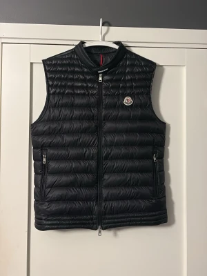 Moncler väst  - Svart moncler väst                                            storlek 3/4=M,L                                                                 Nyskick, använd ett fåtal gånger.                                    Nypris (7000kr). Mitt pris (1500kr) vid snabb och smidig affär kan vi diskutera om priset!                     Dm för minsta lilla fråga!😃